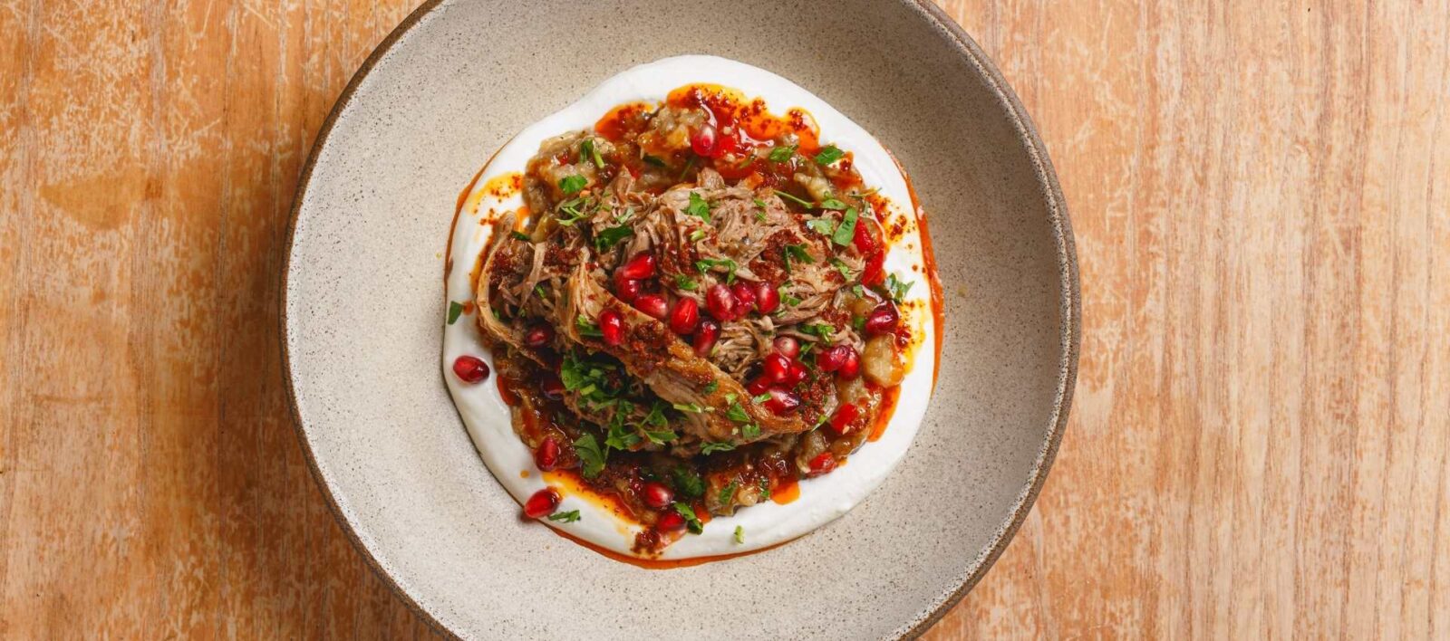 `Slow-cooked lamb shoulder with labneh and pomegranate at Amber restaurant Aldgate East`